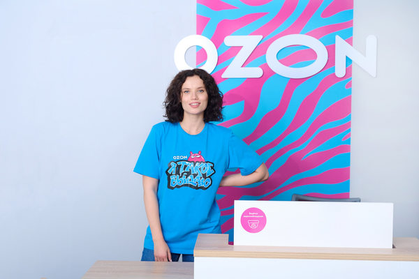 Сотрудница пункта выдачи заказов Ozon за стойкой обслуживания клиентов в ПВЗ