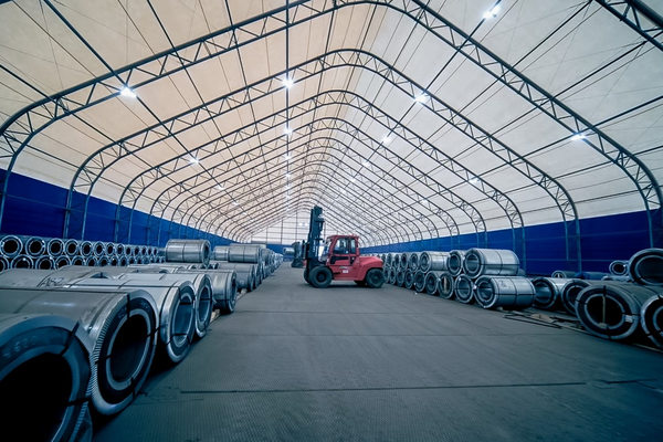 склад металлопроката Северсталь с рулонами стали и погрузчиком внутри складского комплекса