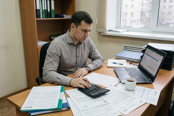 владелец малого бизнеса рассчитывает налоговую нагрузку и документы по НДС в офисе