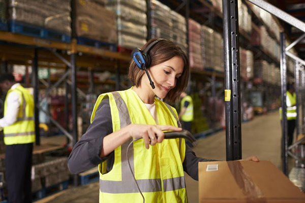 Сотрудник распределительного центра использует технологию голосового отбора Voice Picking при комплектовании заказа на складе
