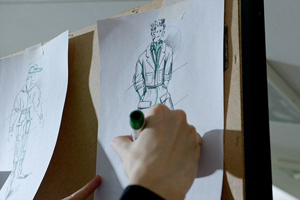 Эскиз дизайна рабочей униформы для сотрудников ритейла X5 на доске с модными набросками