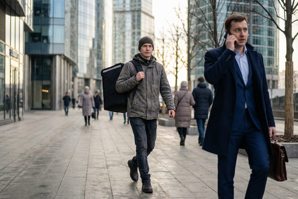 Курьер с термосумкой и офисный сотрудник в деловом районе Москвы — контраст зарплат и рынка труда в сфере доставки