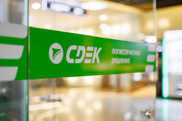 логотип СДЭК на офисной перегородке логистическая компания доставка последней мили