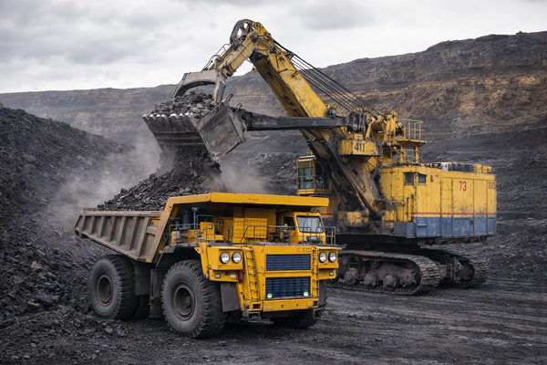 карьер Эльгинского месторождения с карьерным самосвалом и экскаватором при погрузке угля