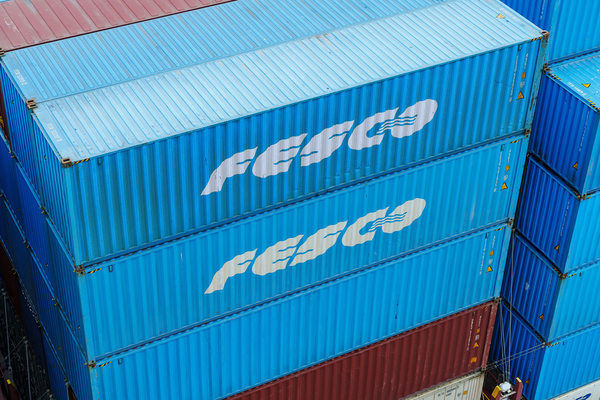 Контейнеры FESCO, сложенные в порту, как символ морских перевозок и логистики