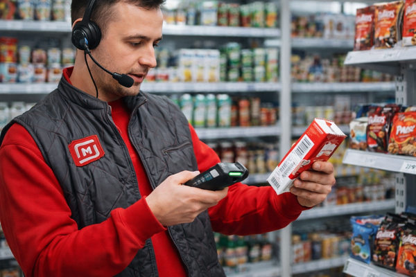 Сотрудник «Магнита» проводит инвентаризацию товаров с помощью сканера и голосового ввода в магазине