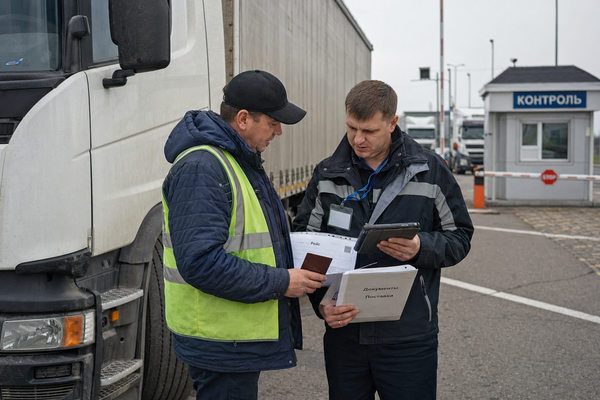 Проверка документов водителя у грузовика на терминале международных автоперевозок