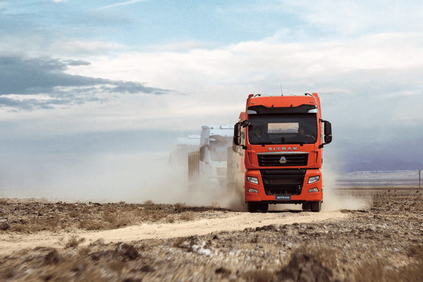 грузовик SITRAK на дороге в пыли — сервис 24/7 и эксплуатация грузовой техники
