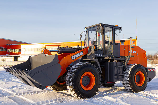 фронтальный погрузчик UMG WL50 на строительной площадке зимой, спецтехника для коммунальных работ