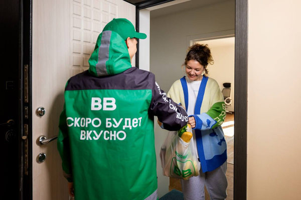 курьер доставляет продукты из ВкусВилл клиенту на дом, рост онлайн-доставки и снижение роли офлайн-магазинов
