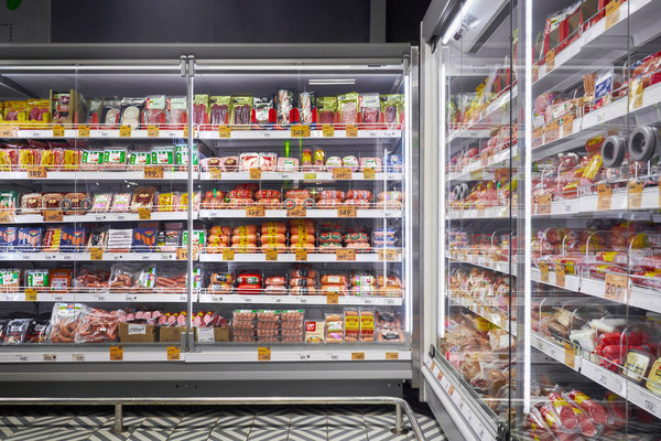 Полки продуктового магазина с товарами и ценниками для статьи о цифровом контроле выкладки и управлении запасами
