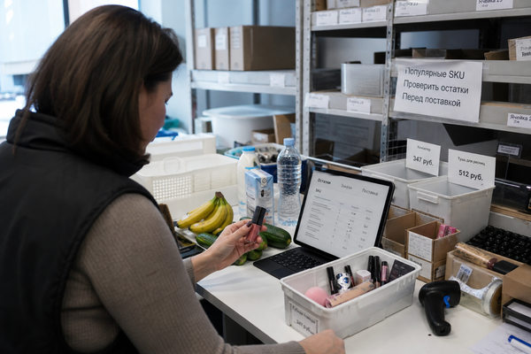 Сотрудник quick commerce сверяет SKU косметики и продуктов для управления ассортиментом и запасами