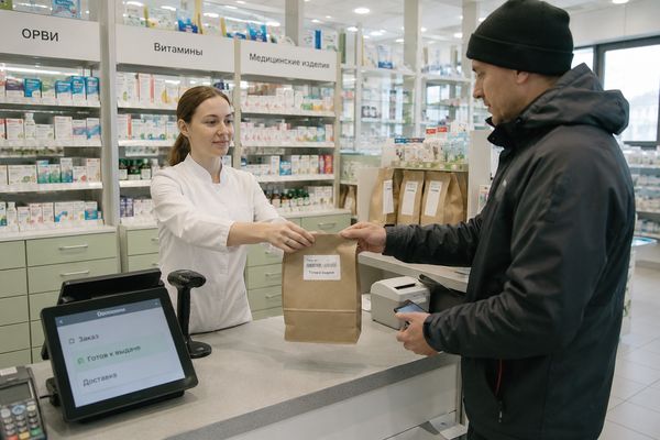 Курьер получает аптечный онлайн-заказ в зоне выдачи, last mile в аптечном e-commerce
