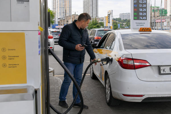 Водитель такси заправляет автомобиль на АЗС на фоне топливного дефицита и снижения доступности такси