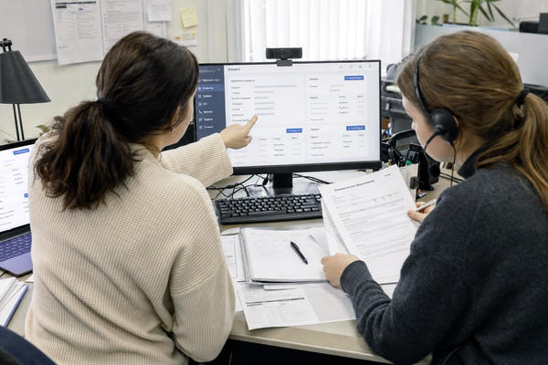 Сотрудники офиса сверяют клиентские данные в CRM для автоматизации бизнес-процессов и информационных потоков
