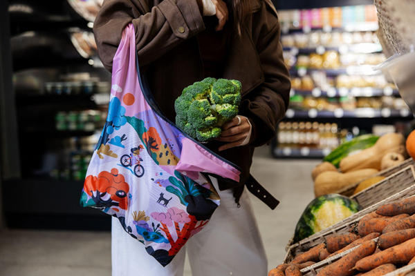 Покупатель с многоразовой сумкой в продуктовом магазине: упаковочные потоки и SKU в ритейле