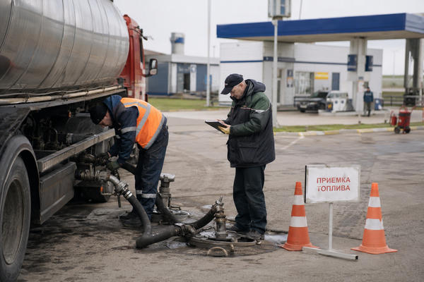 Бензовоз сливает топливо в резервуары АЗС во время приемки поставки