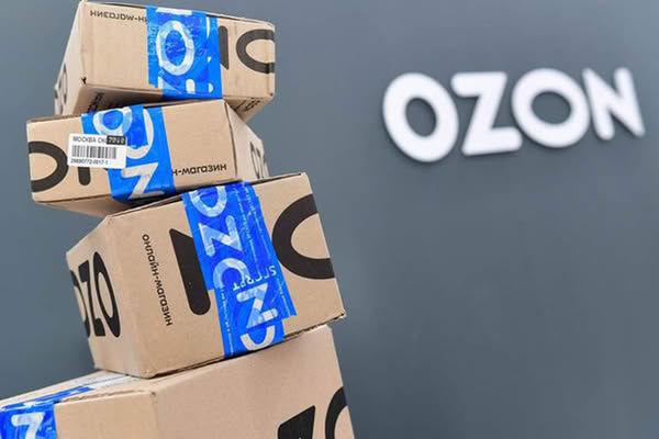 Коробки Ozon на фоне логотипа компании — доставка для бизнеса и заказы вне маркетплейса