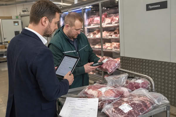 Сотрудники супермаркета проверяют поставку охлажденной говядины в зоне приемки