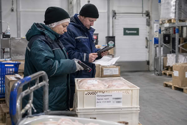 Сотрудники распределительного центра принимают партию охлажденного мяса птицы