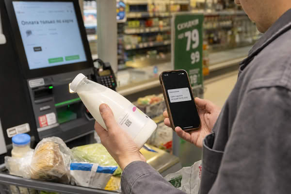 Покупатель в продуктовом магазине проверяет уведомление о сроке годности маркированного товара после покупки