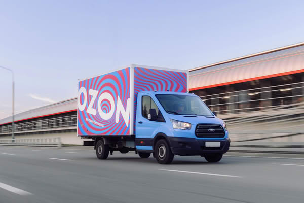 Грузовой автомобиль Ozon на фоне логистического комплекса — транспортная инфраструктура в контексте сделки ПЭК и Ozon Лизинг