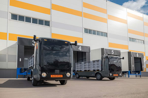Автономные грузовики Evocargo у погрузочных доков предприятия — беспилотный транспорт для внутренней логистики