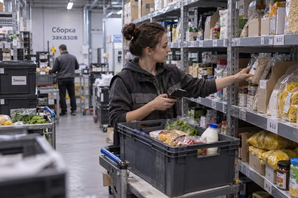 Комплектовщик собирает онлайн-заказ в продуктовом дарксторе — инфраструктура экспресс-доставки и управления запасами