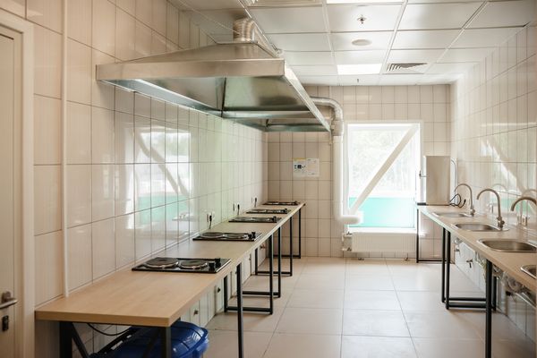 Кухонная зона в новом общежитии Ozon для сотрудников складов: плиты, вытяжки, мойки и рабочие поверхности, организованные для комфортного самостоятельного приготовления пищи.