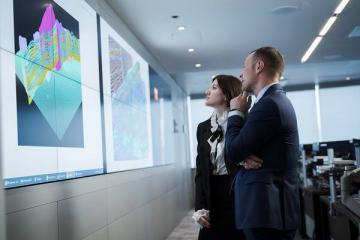 Сотрудники «Газпром нефти» анализируют геологические 3D-модели месторождений на цифровом экране в аналитическом центре компании
