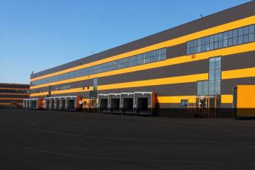 Складской комплекс «Октавиан» в Ленинградской области: фасад с доковыми воротами и рампами — площадка аренды 3,3 тыс. м² оператором «Магнитогор»