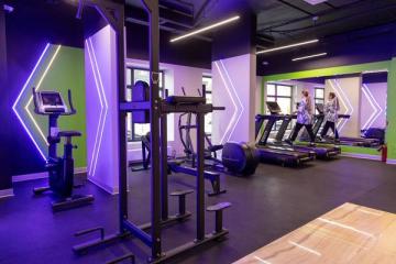 Интерьер автоматизированного фитнес-клуба XFIT Point с современными тренажёрами и неоновым освещением в ЖК «Новая Рига»