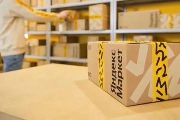 Упаковка Яндекс Маркета на складе с фирменной жёлтой лентой и логотипом