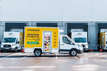 Фургон службы доставки «Утконос» на фоне логистического центра — переход от e-commerce к офлайн-ритейлу в условиях трансформации дистрибуции