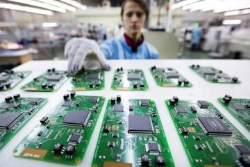Работник в перчатках проверяет электронные микросхемы на производственной линии — символ поддержки радиоэлектроники за счёт пошлин на маркировку товаров