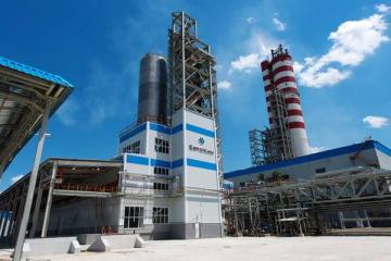 Производственная площадка ЕвроХима с промышленными башнями и трубами на фоне синего неба — объект, где внедрена система цифрового мониторинга оборудования